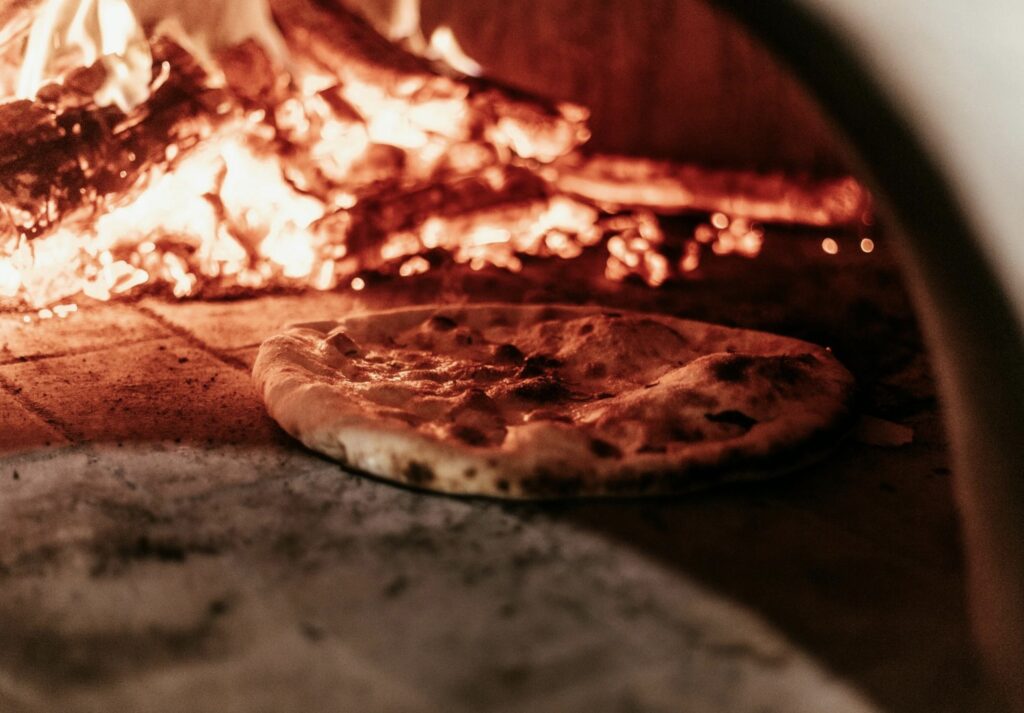 image shows pizza from a wood-fired oven like the type they serve at Meno Male restaurant in Stockholm